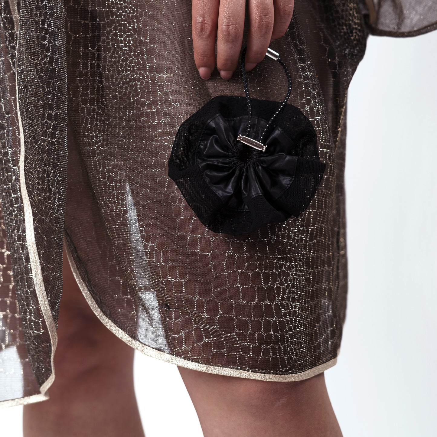 Model holding the black ripstop nylon and mesh scrunchie, styled naturally to demonstrate comfort and elegance.