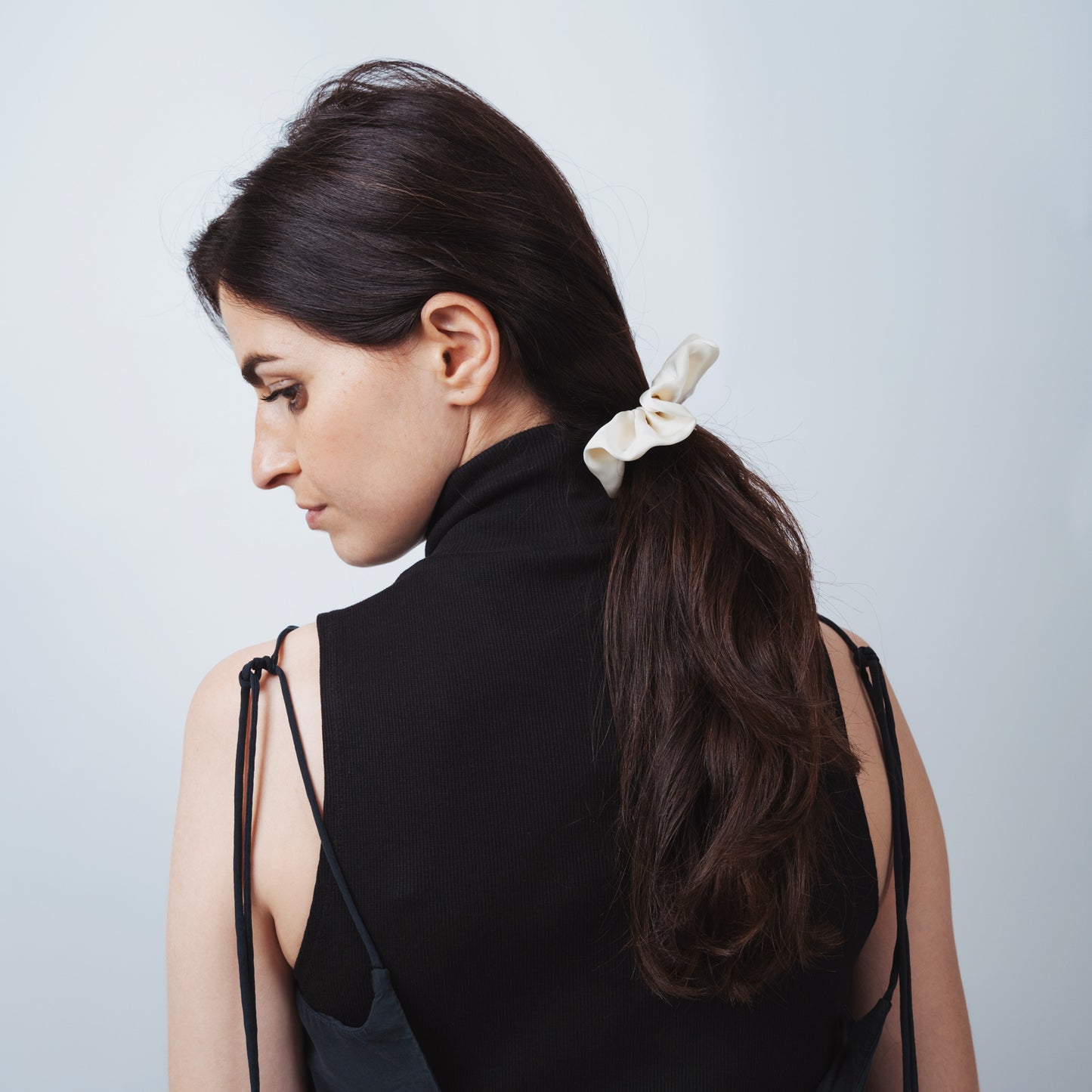 Model wearing the ivory silk scrunchie, showing comfort, adjustability, and refined everyday elegance.