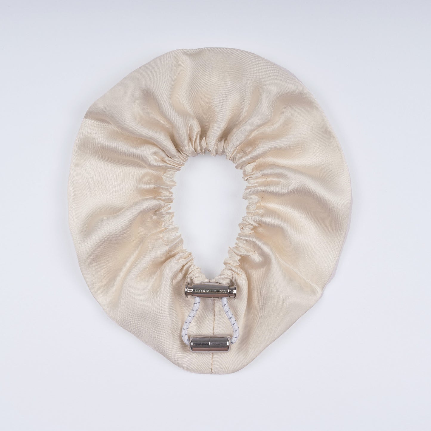 Ivory silk scrunchie opened fully, highlighting flexible elastic and luxurious silk material.