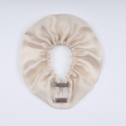 Ivory silk scrunchie opened fully, highlighting flexible elastic and luxurious silk material.