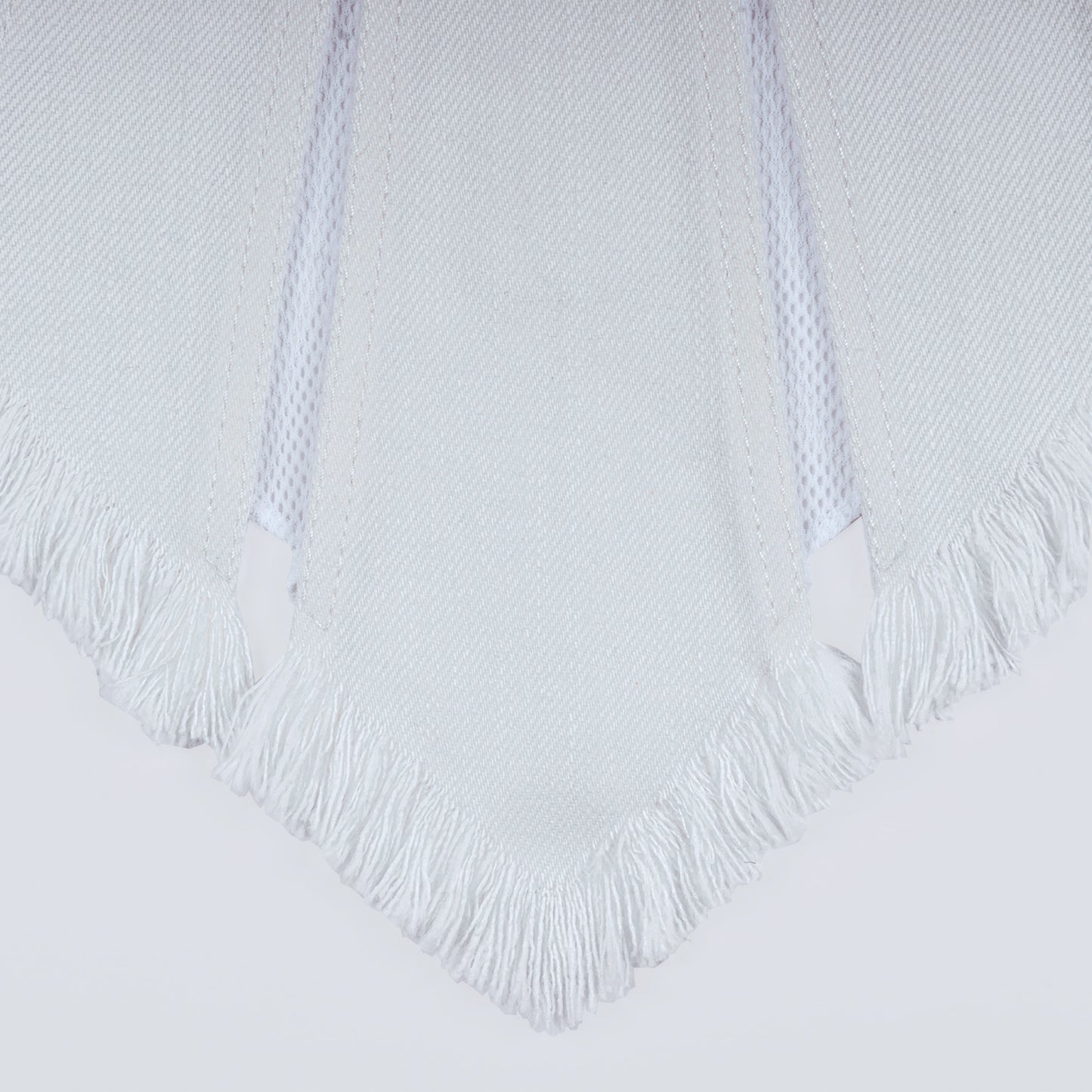 Close-up of white denim and sheer mesh fabric under natural light