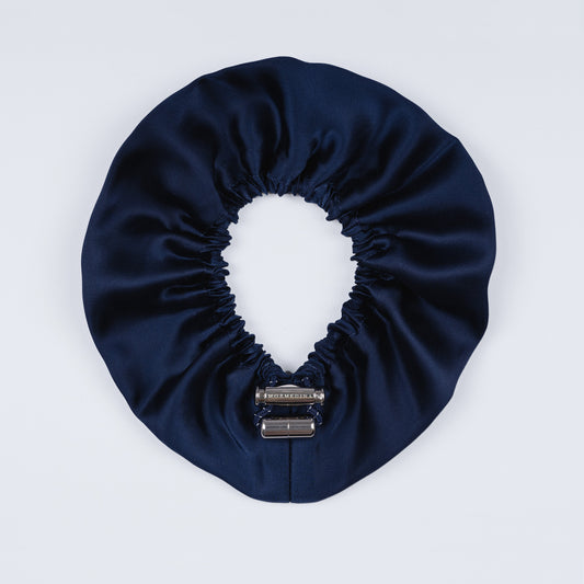 Night blue silk scrunchie opened fully, revealing flexible elastic and luxurious silk material.