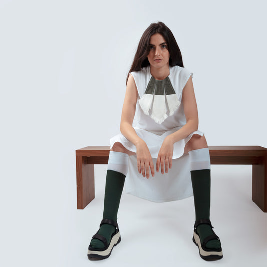 Model layering the collar over a white dress