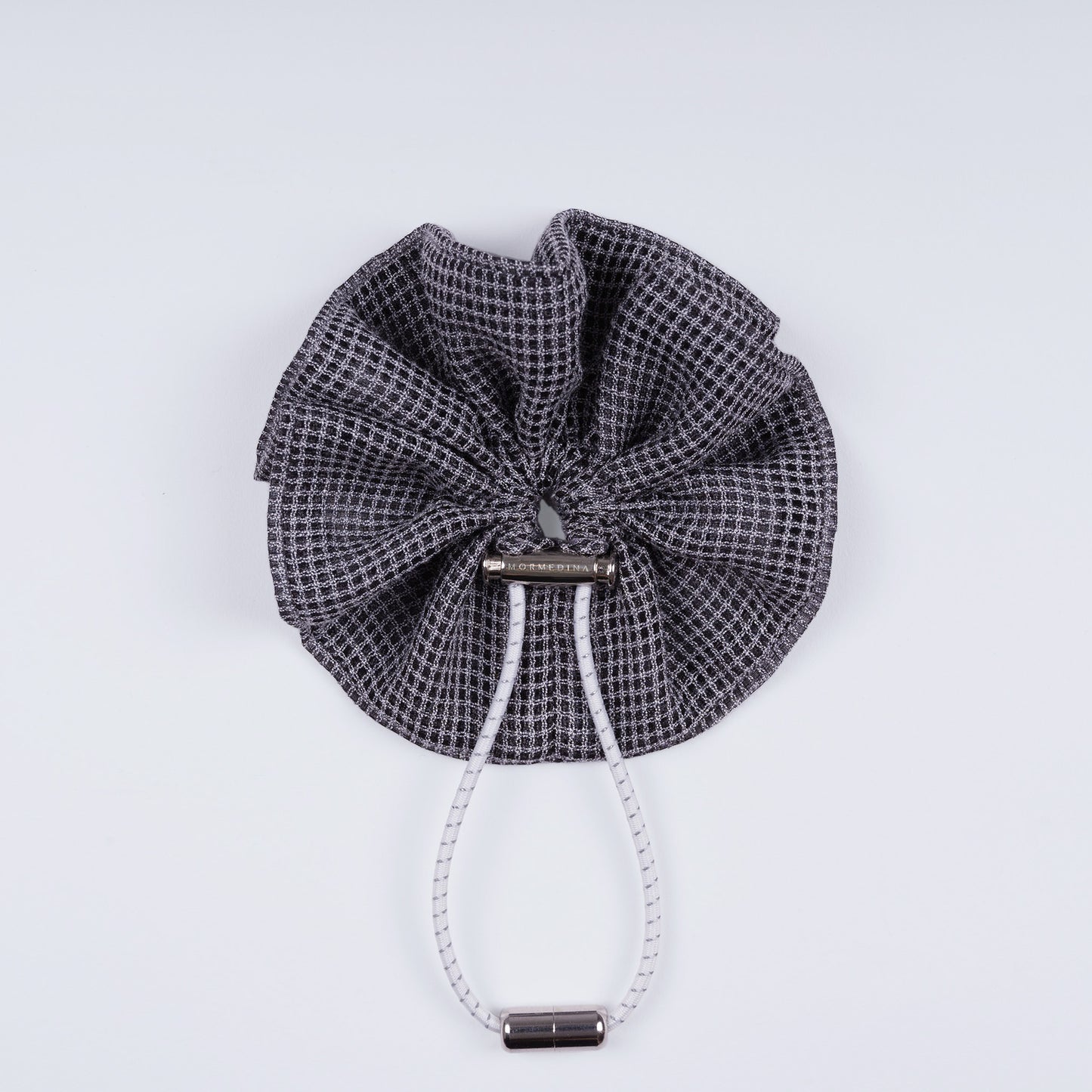 Gray squares adjustable scrunchie displayed closed on a white background, highlighting its unique fastener.