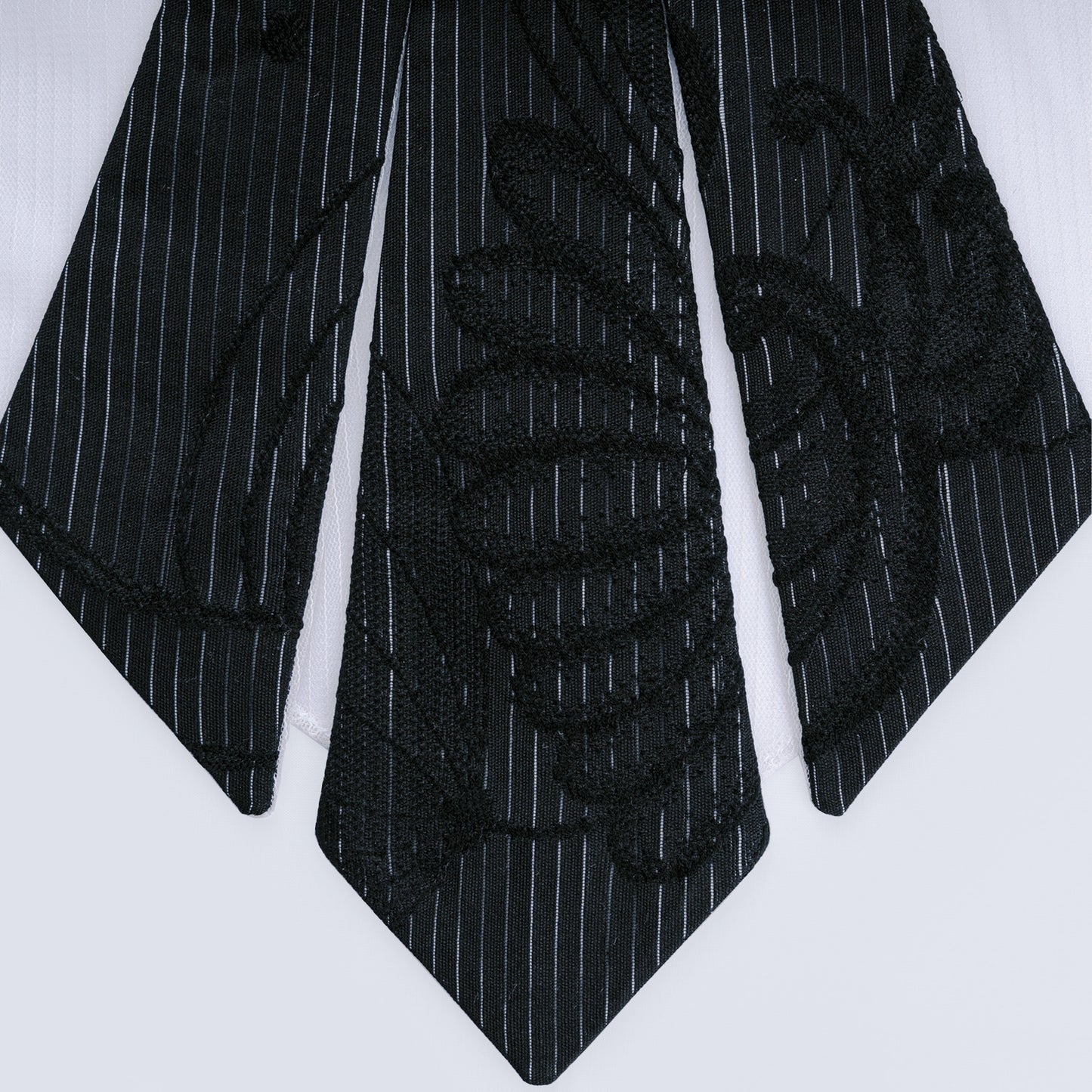 Close-up of black floral and striped silk with white sheer mesh