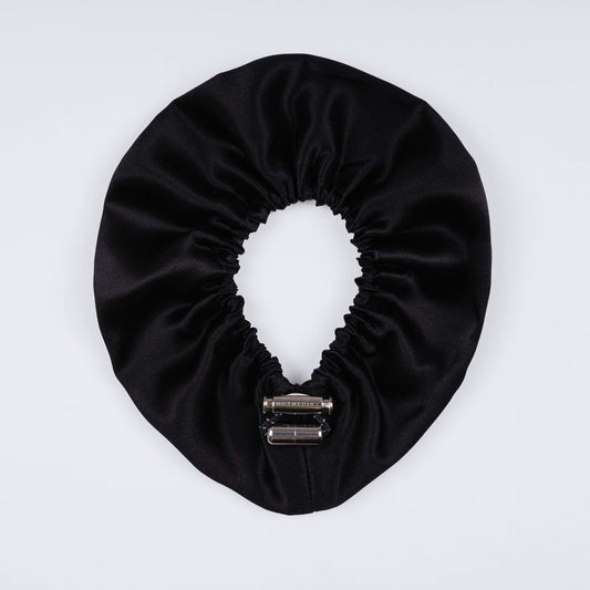 Black silk scrunchie opened fully to reveal flexible elastic and smooth luxurious material.