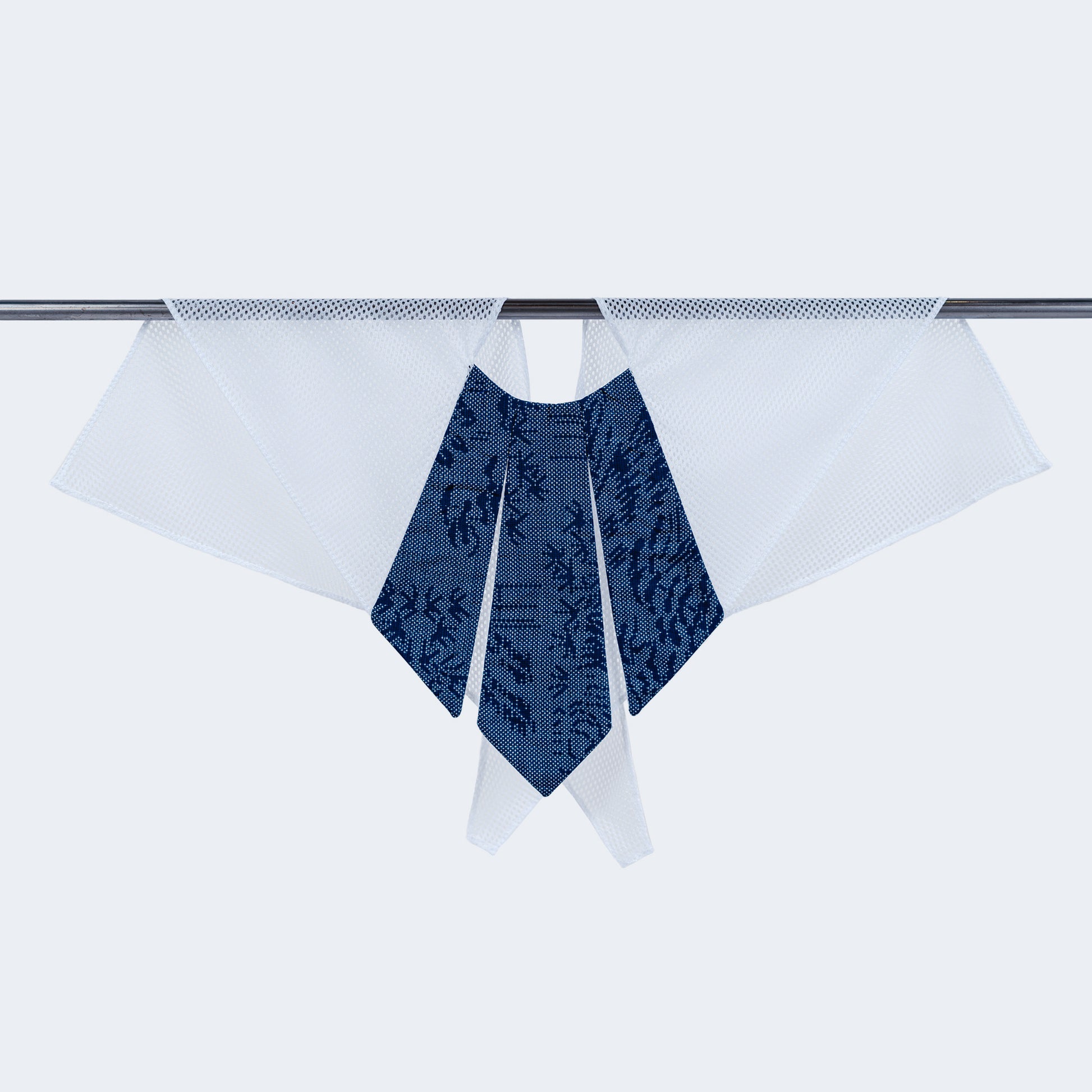 A dotted blue and white scarf with a unique collar design, displayed on a hanger.