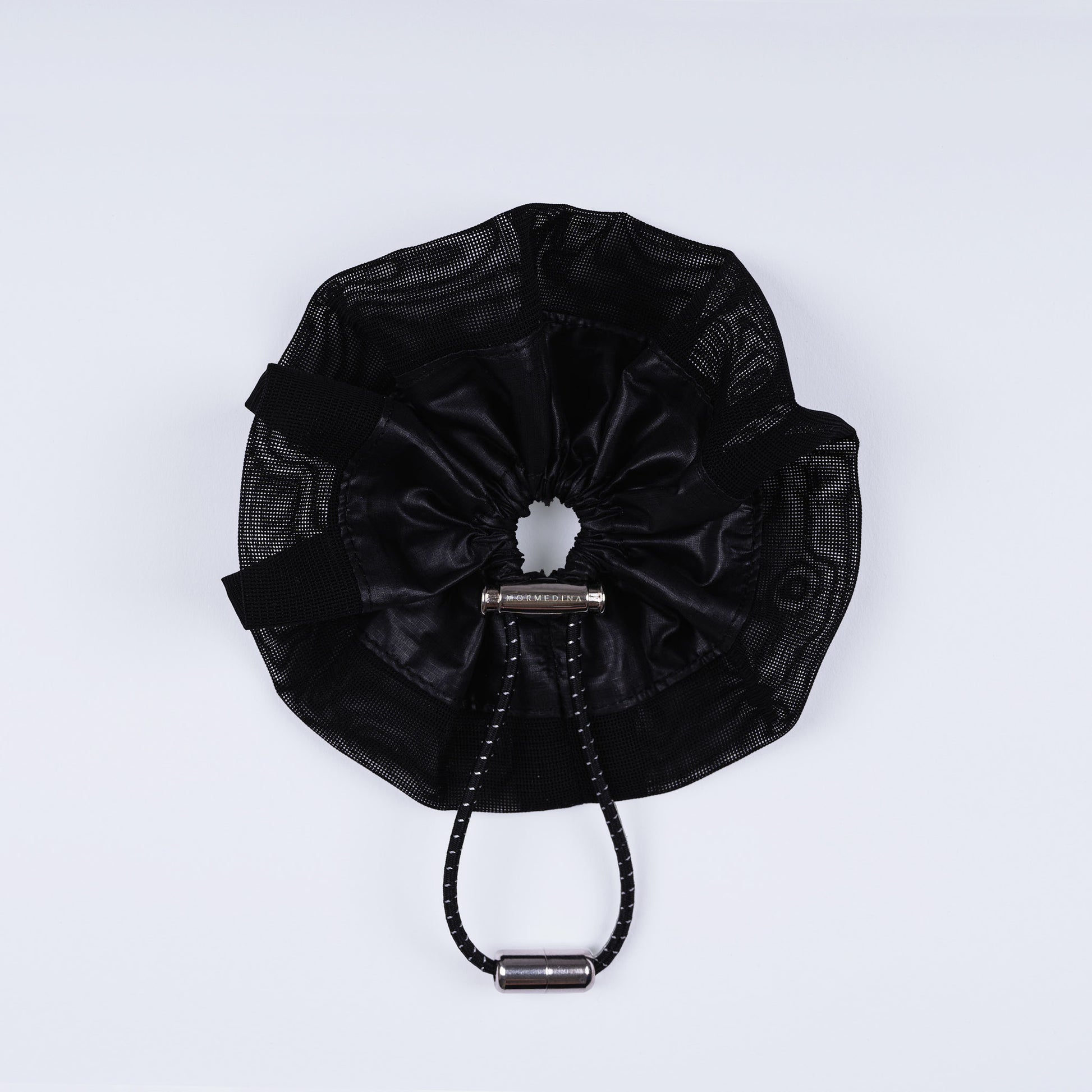 A black ripstop nylon and mesh adjustable scrunchie, displayed closed on a white background to show its sleek fastener design.
