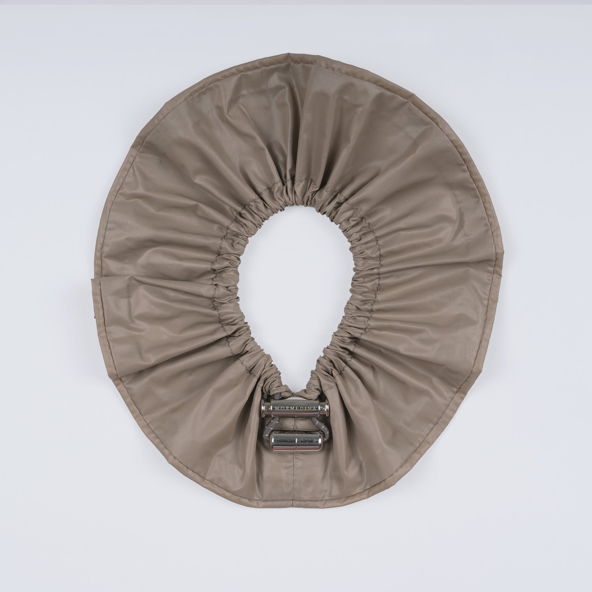 A khaki nylon adjustable hair band shown fully open from above, highlighting the smooth nylon material and innovative fastener.