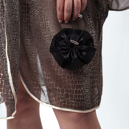 Model holding the black ripstop nylon and mesh scrunchie, styled naturally to demonstrate comfort and elegance.