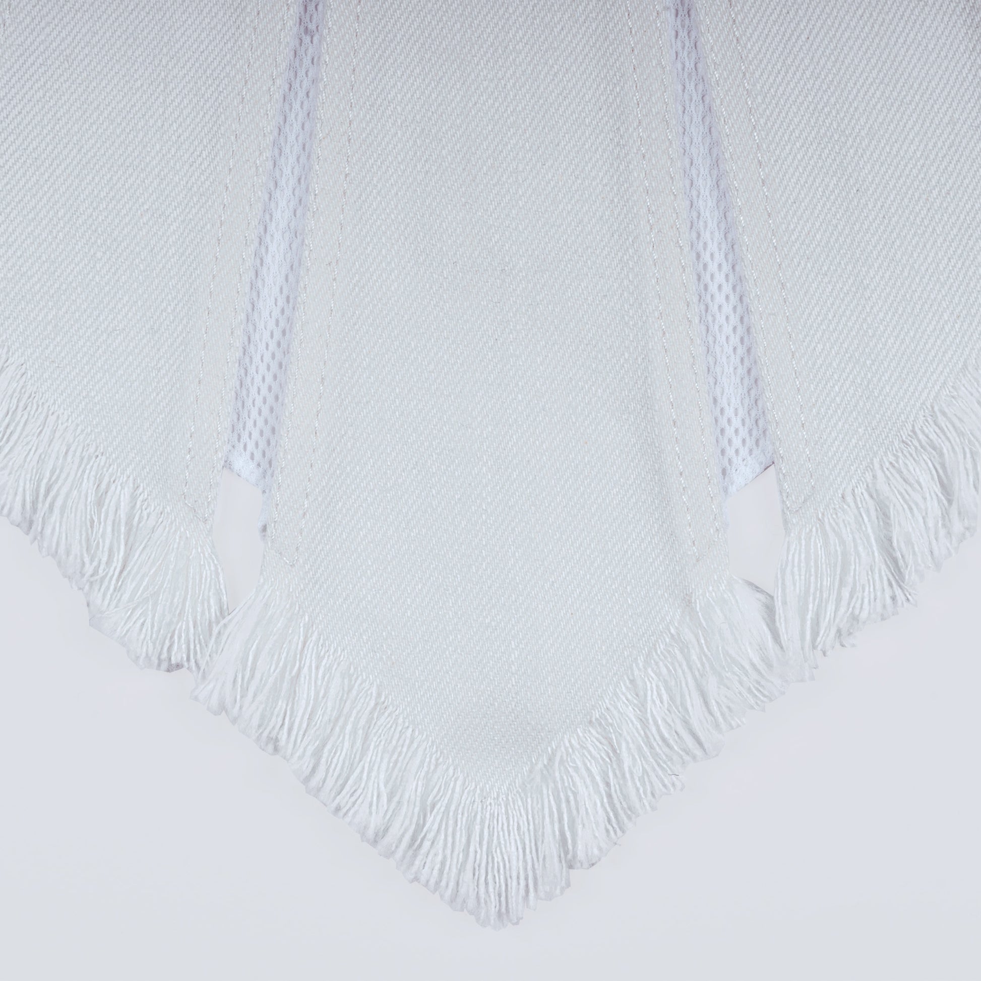 Close-up of white denim and sheer mesh fabric under natural light
