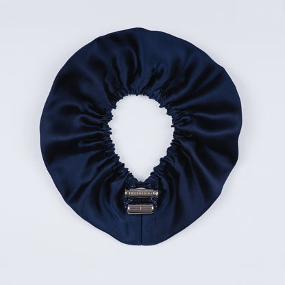 Night blue silk scrunchie opened fully, revealing flexible elastic and luxurious silk material.