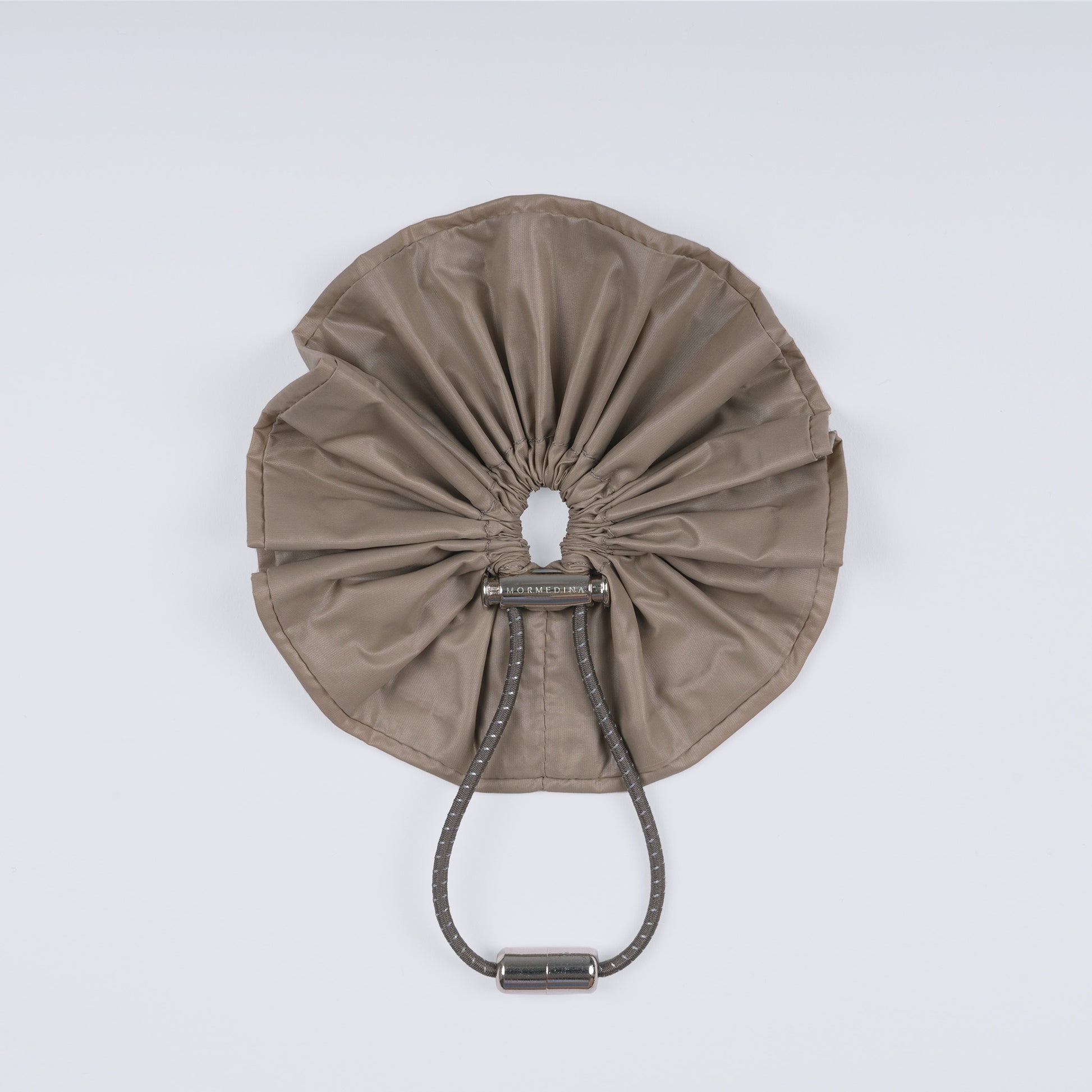 A khaki nylon adjustable hair band with a unique fastener, displayed closed on a white background.