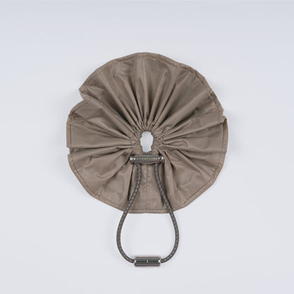 A khaki nylon adjustable hair band with a unique fastener, displayed closed on a white background.