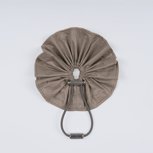 A khaki nylon adjustable hair band with a unique fastener, displayed closed on a white background.