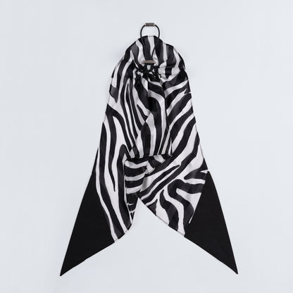 Black and white zebra print silk scrunchie displayed closed on a white background, highlighting the unique fastener and smooth texture.