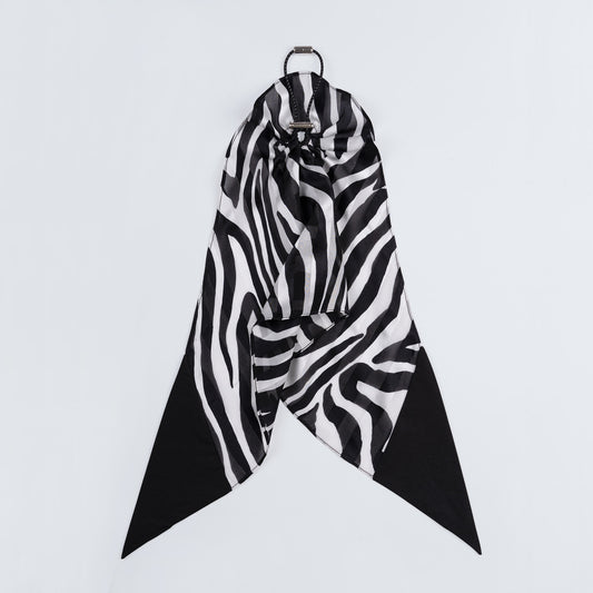 Black and white zebra print silk scrunchie displayed closed on a white background, highlighting the unique fastener and smooth texture.