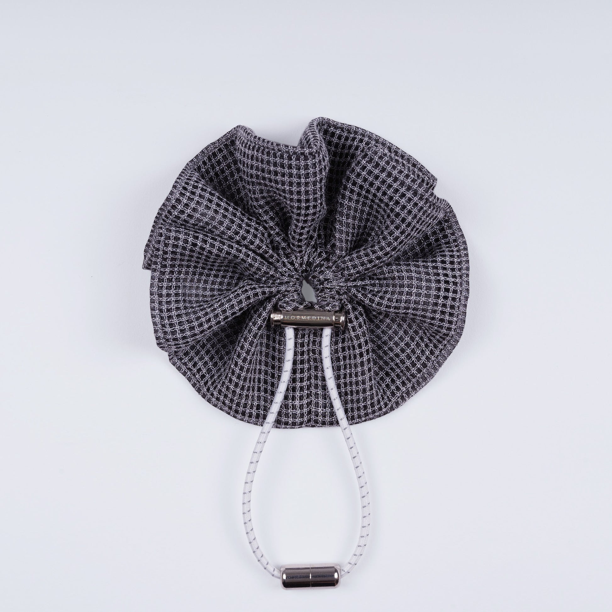 Gray squares adjustable scrunchie displayed closed on a white background, highlighting its unique fastener.