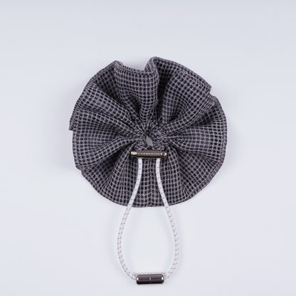 Gray squares adjustable scrunchie displayed closed on a white background, highlighting its unique fastener.