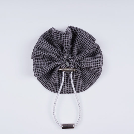 Gray squares adjustable scrunchie displayed closed on a white background, highlighting its unique fastener.