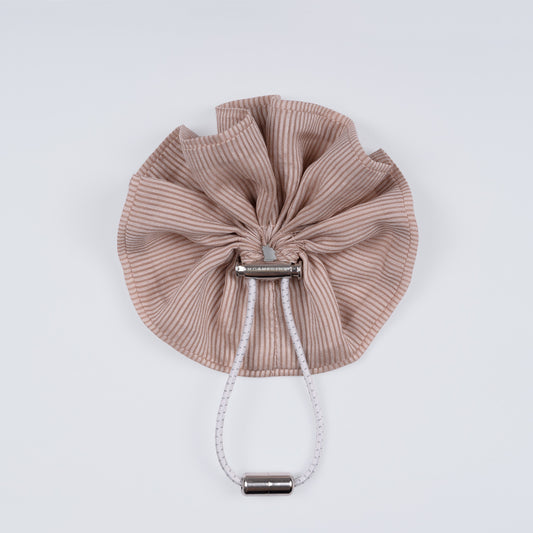 Nude brown and pink striped scrunchie displayed closed on a white background, showing the unique fastener.
