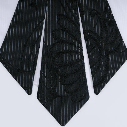 Close-up of black floral and striped silk with white sheer mesh